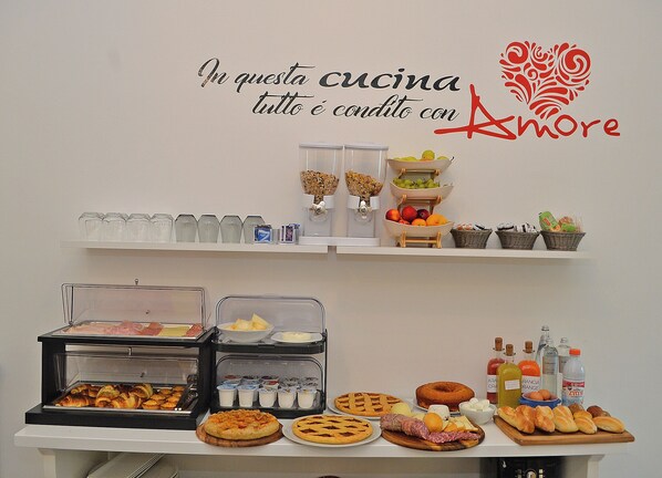 A buffet setup with various food items and beverages, including pastries, fruits, and condiments. - Hotiday Lecce Gianmarti Suite (Lecce)