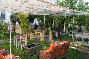 Ein möblierter Patio-Bereich mit Sitzgelegenheiten und Tischen im Schatten.