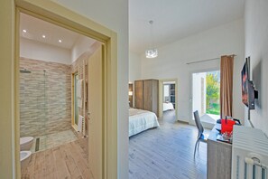 A modern hotel room with a shower, a bed, a desk, and a view of the outdoors. - Hotiday Lecce Gianmarti Suite (Lecce)