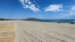 A wide sandy beach with a wooden boardwalk, umbrellas, and people relaxing. - Veramarinas apartment - relax and privacy (AN)