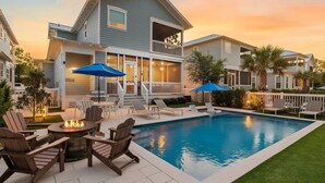 A residential property with a swimming pool, outdoor seating, and a fire pit.