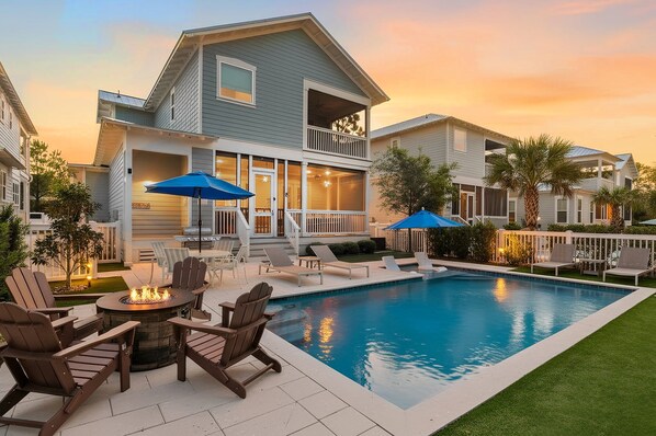 A residential property with a swimming pool, outdoor seating, and a fire pit.