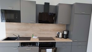 A compact kitchen with a microwave, coffee maker, and dishwasher. - Alpaca Lodge Kirchwahlingen (Kirchwahlingen)