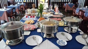 A buffet setup with multiple serving dishes, including hot pots and a variety of food items. - Hotel princesinha do cafe (Vassouras)