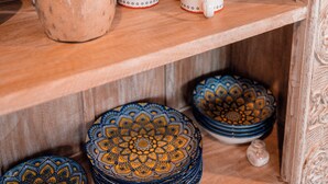 Een houten plank met diverse keramieken voorwerpen, waaronder kommen, mokken en potten.