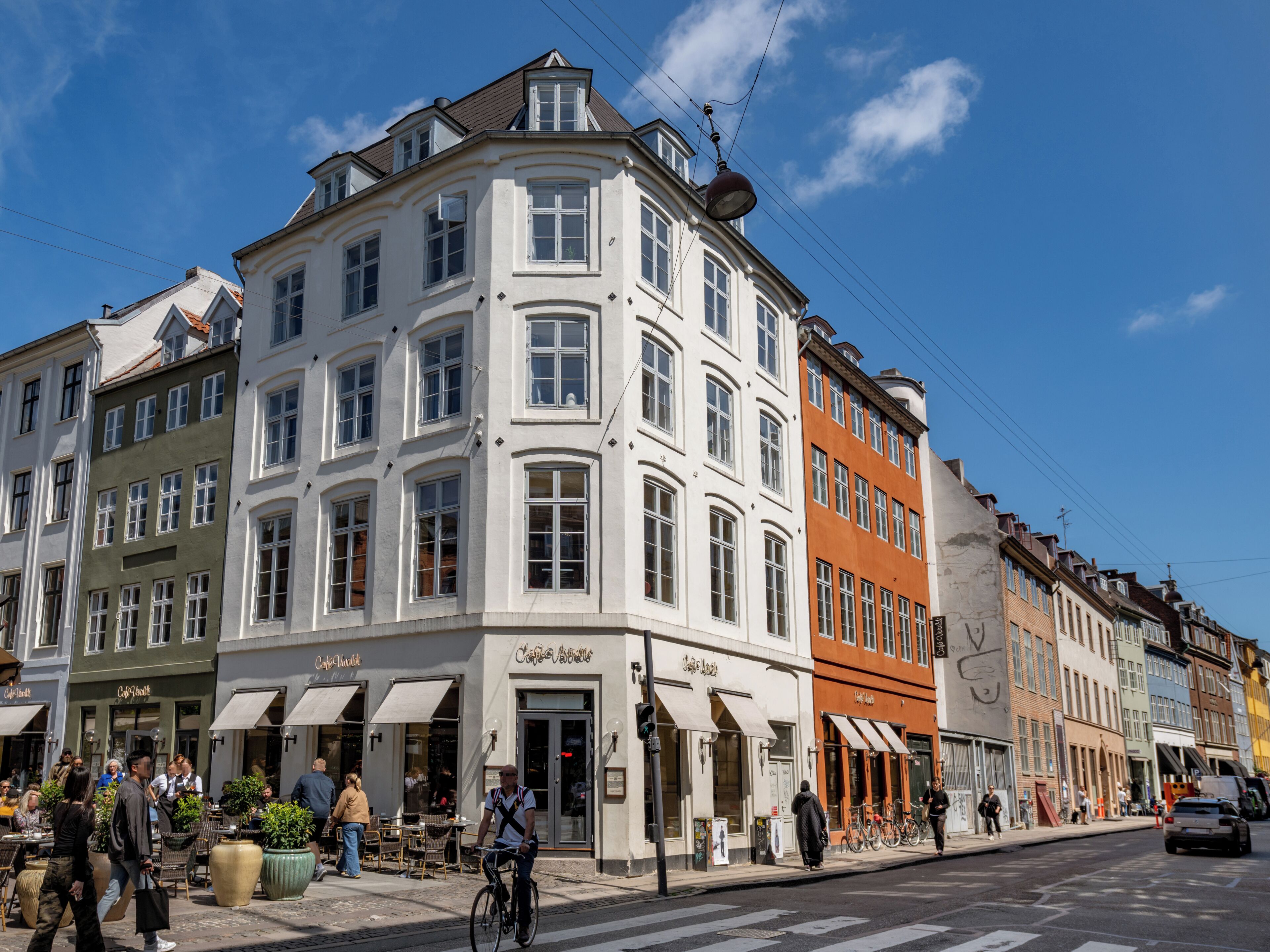 A corner building with multiple storefronts, including a cafe and a restaurant.