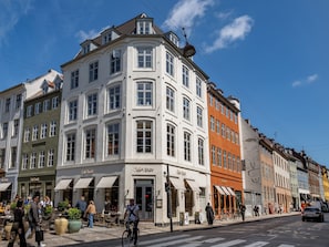 A corner building with multiple storefronts, including a cafe and a restaurant. - Regent 16- Bright Apartment in City Center (Copenhagen)