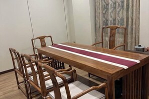 A wooden dining table with a red runner, surrounded by matching chairs. - Super8 Yuet Hotel (Beijing Qilizhuang Branch) (Beijing)