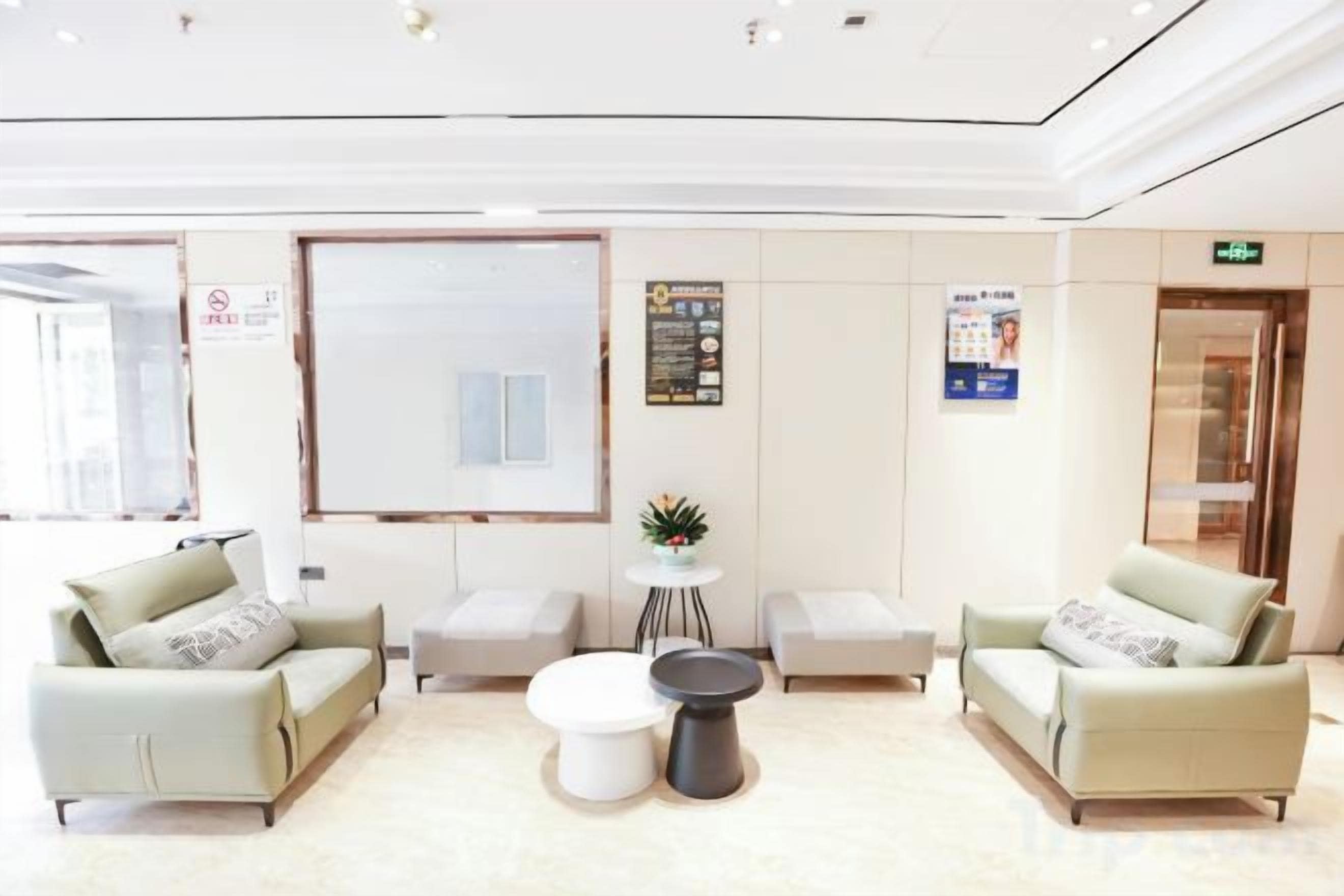 En hotellobby med sittgrupper, en receptionsdisk och informationsaffischer på väggarna.