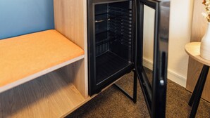 A compact kitchen with a built-in oven, a wooden bench, and a small table with a vase. - Myky Hotel Pinneberg (Pinneberg)