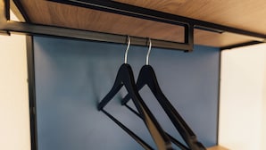 A wooden ceiling with a black metal rack holding two black hangers. - Myky Hotel Pinneberg (Pinneberg)