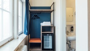 A compact room with a built-in wardrobe, a small sink, and a radiator. - Myky Hotel Pinneberg (Pinneberg)