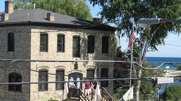 Un bâtiment en pierre de deux étages, doté d’un balcon et d’un drapeau.