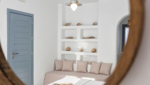 Ein Schlafzimmer mit einem Bett, einer blauen Tür, einer weißen Wand und einem Regal mit Dekoration.