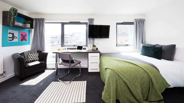 A modern hotel room with a desk, chair, bed, and large windows. - For Students Only Prospect Point in Liverpool (Liverpool)