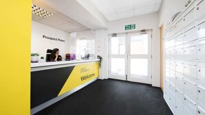 A reception area with a 'Welcome' sign, a 'Prospect Point' sign, and a fire exit sign. There are lockers on the right and a receptionist behind the counter. - For Students Only Prospect Point in Liverpool (Liverpool)