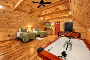 Une chambre confortable avec deux lits, un baby-foot et une télévision.