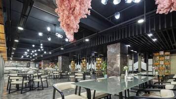 A spacious restaurant with high ceilings, hanging floral decorations, and multiple seating areas.