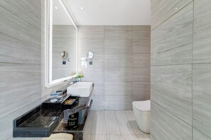 A modern bathroom with a large mirror, a sink, and a toilet. - Aoshang Hotel (Hanzhong High-speed Railway Station) (Hanzhong)