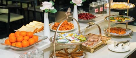 Um buffet com diversos alimentos e detalhes decorativos.
