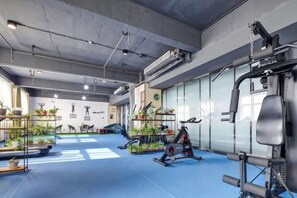 A gym with exercise equipment, mirrors, and potted plants. - Aoshang Hotel (Hanzhong High-speed Railway Station) (Hanzhong)