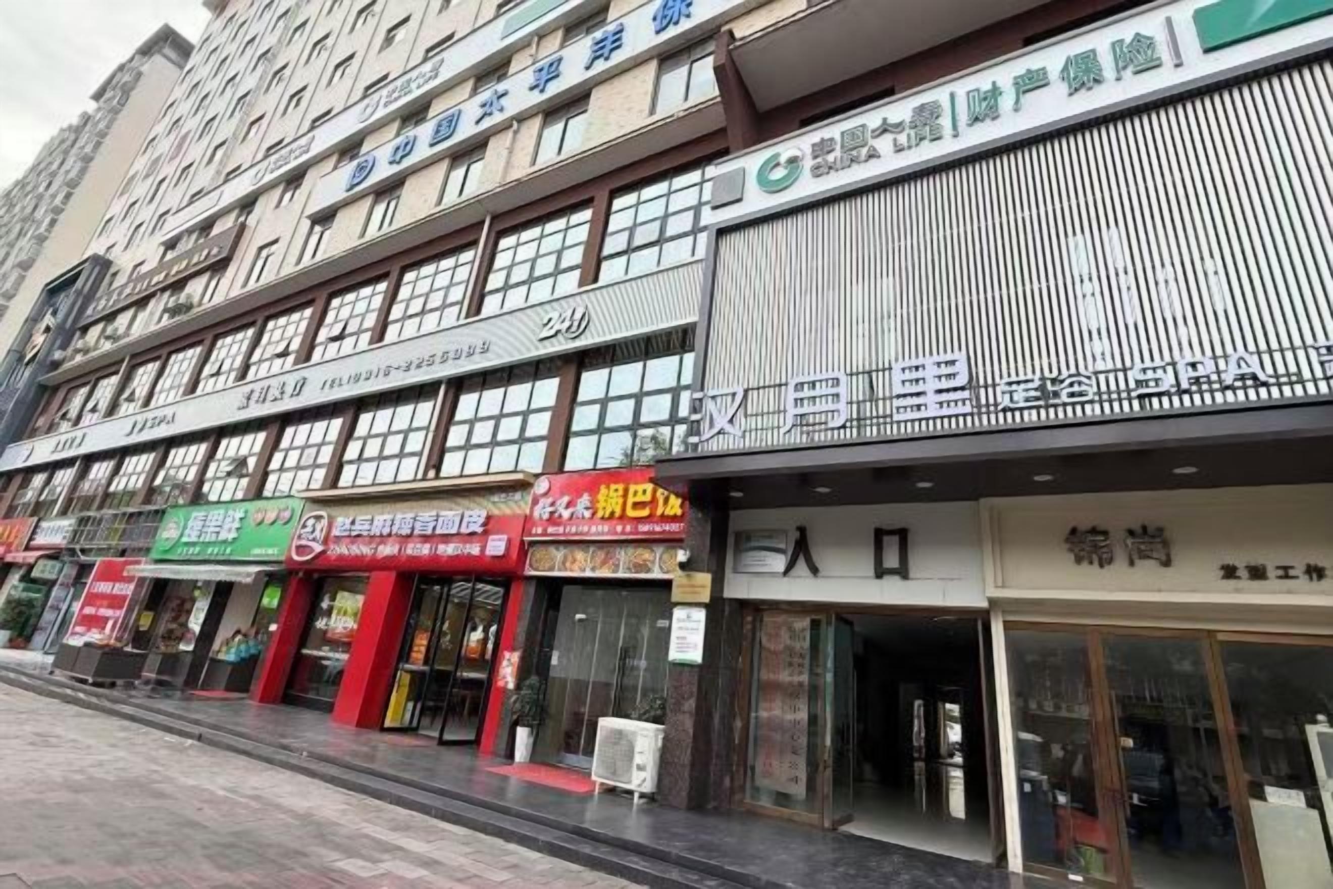 A multi-story commercial building with various storefronts, including a pharmacy and a restaurant.