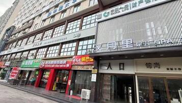 A multi-story commercial building with various storefronts, including a pharmacy and a restaurant.