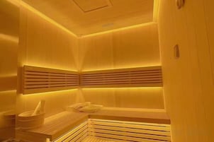 Una sauna con bancos de madera y un diseño de techo con listones.