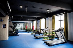 Un gimnasio con cintas de correr, bicicletas estáticas y máquinas de pesas.