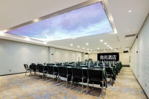 A conference room with a starry sky projection on the ceiling, a long table with chairs, and a sign indicating a hotel location. - Aoshang Hotel (Hanzhong High-speed Railway Station) (Hanzhong)