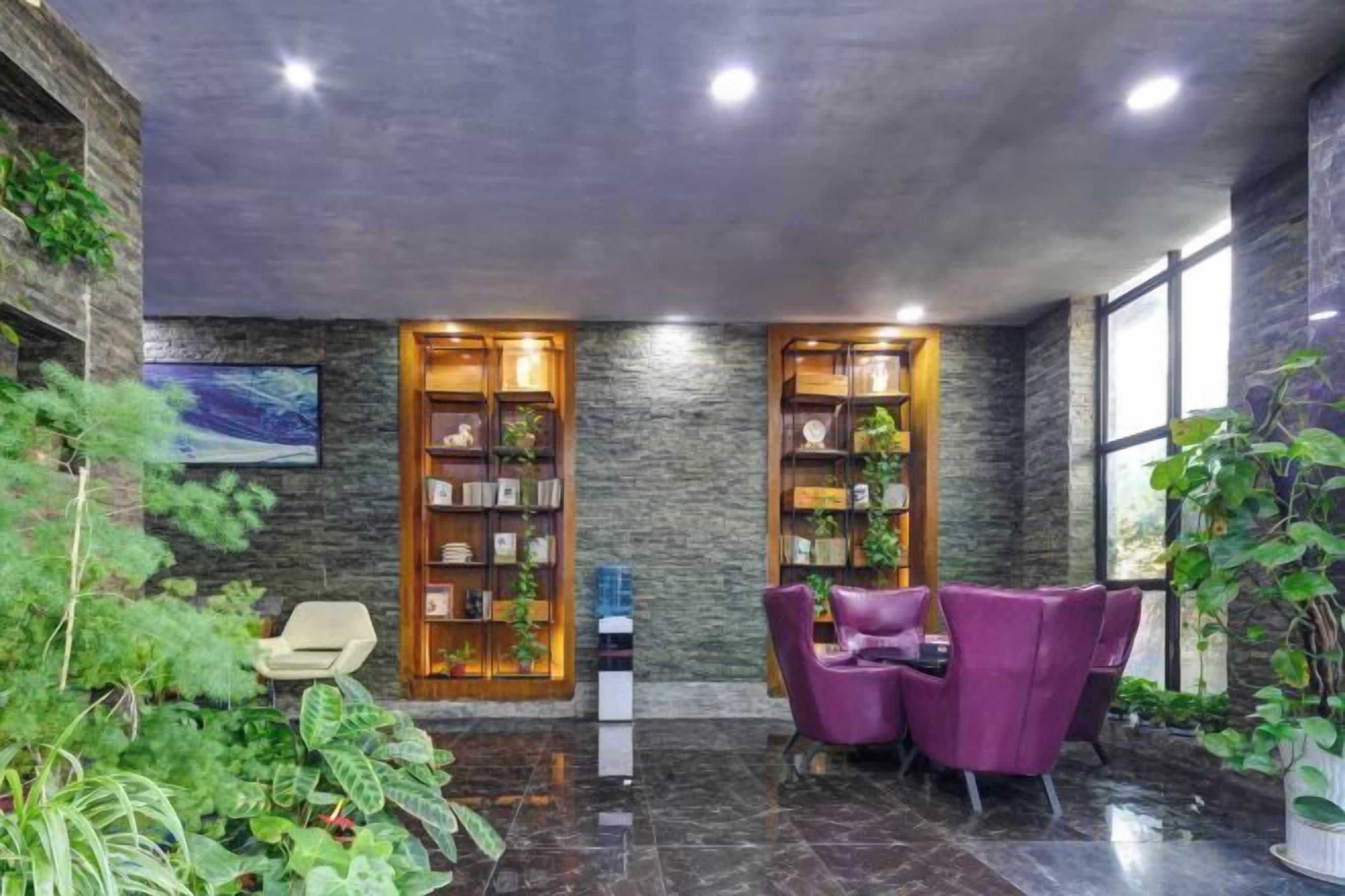 A modern interior with a seating area, two wooden bookshelves, and a large window.