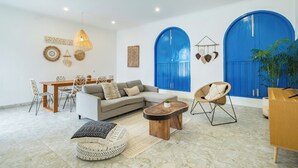 A modern living room with a sofa, coffee table, and dining area. - Casa Posa Seminyak (Seminyak)