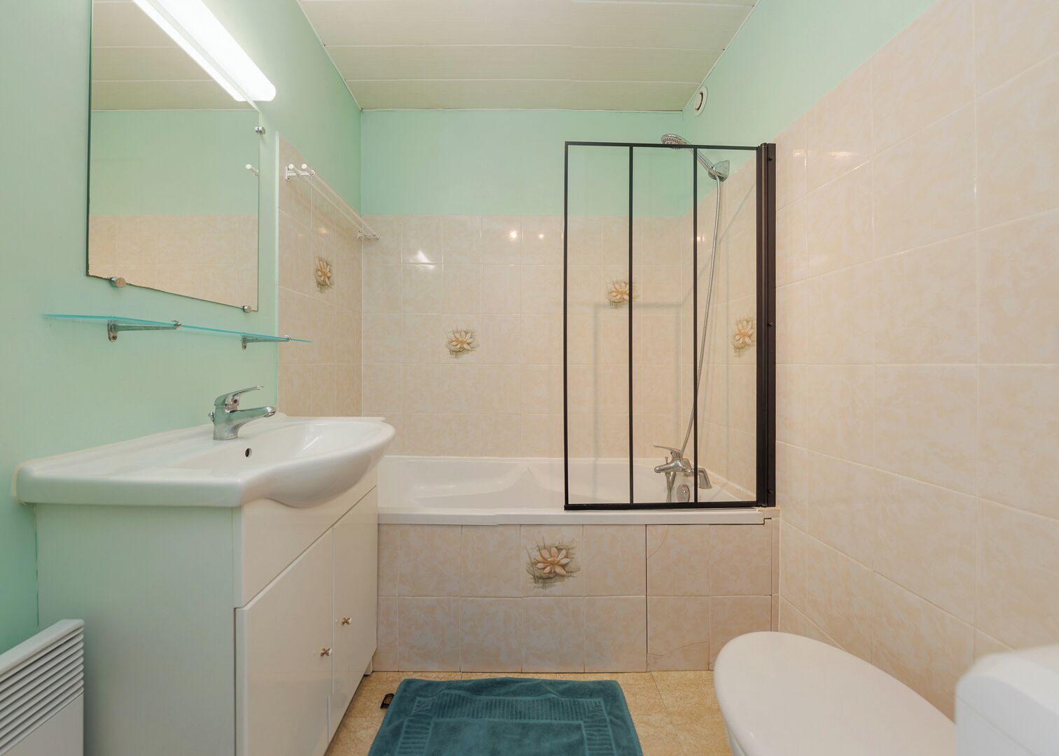 A bathroom with a sink, mirror, bathtub, shower, and toilet.