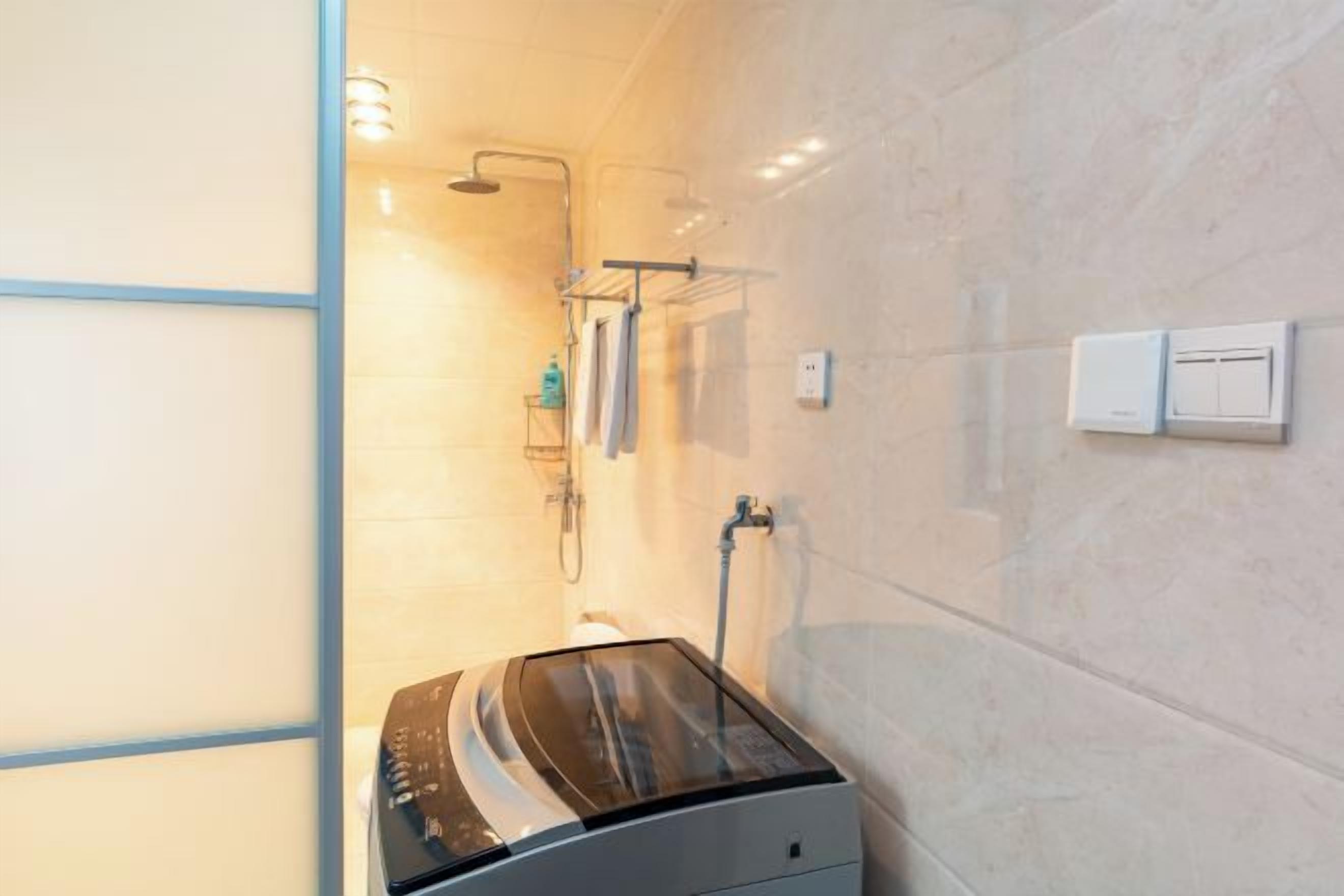 Une salle de bain moderne dotée d’une cabine de douche en verre, d’un radiateur intégré et d’un porte-serviettes.