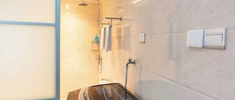 Une salle de bain moderne dotée d’une cabine de douche en verre, d’un radiateur intégré et d’un porte-serviettes.