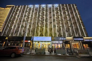 A multi-story hotel with a modern facade, featuring a series of windows and a prominent entrance. - Sangel Hotel (Zhengzhou East Longhai Road Metro Station) (Zhengzhou)