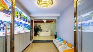 A hotel lobby with a reception desk, seating area, and decorative posters on the walls. - Holiday Inn Lijiang Langtai (Lijiang)