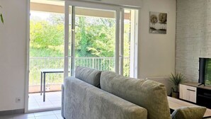 Een woonkamer met een bank, een televisie en een open haard.