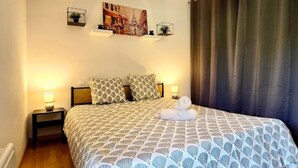 Een keurig opgemaakt slaapkamer met een bed, twee nachtkastjes, een wandplank met een plant en een schilderij van een stadsgezicht.