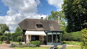 A house with a covered porch and a glass conservatory. - Renovated bread oven in pretty Normandy property (Étréville)