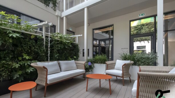 A modern outdoor seating area with a white sofa, two armchairs, and a small orange table. - HOTIDAY Room Collection - Milano Cinque Giornate (Milan)