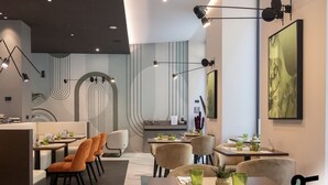 A modern restaurant interior with tables, chairs, and ambient lighting. - HOTIDAY Room Collection - Milano Cinque Giornate (Milan)