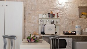 Una cocina compacta con pared de piedra, cafetera y microondas.