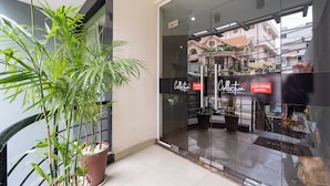 A hotel entrance with glass doors, a potted plant, and a sign for the Lan Rung Hotel. - Collection O District 10 Near Van Hanh Hospital Formerly Lan Rung Hotel (Ho Chi Minh City)