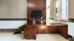 A modern bathroom with a wooden vanity, a built-in sink, a mirror, and a television mounted on the wall. - Collection O District 10 Near Van Hanh Hospital Formerly Lan Rung Hotel (Ho Chi Minh City)