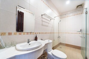A bathroom with a sink, toilet, and glass-enclosed shower.
