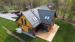 A modern two-story house with a sloped roof, large windows, and a covered outdoor area. - Villa Albatros Paradise in the middle of Lauzitzer Gebirge and Golf Resort Malevil (Liberecký kraj)