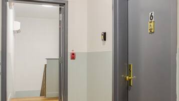 Un pasillo con una señal de salida, una puerta con el número 6 y el número 4 en la pared.