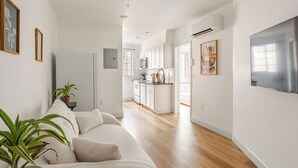 Een modern appartement met een woonkamer, keuken en eethoek.