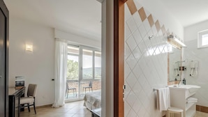 Un baño moderno con un espejo grande, un lavabo y una zona de ducha.